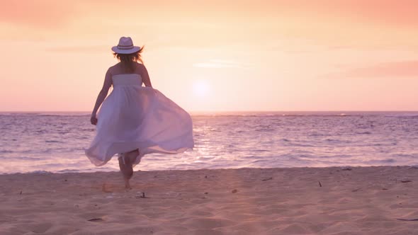 Young Bride in White Flying Wedding Dress Running By Beach to Pink Sunset on RED
