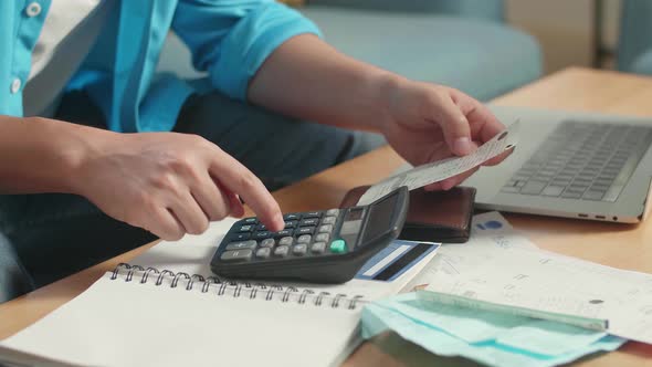 Close Up Of Man's Hand Holding Bill And Calculating Money By Calculator