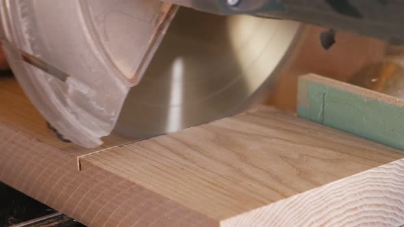 Worker Sawing a Wood Board with a Circular Saw. Close-up Hands