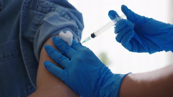 Young lady nurse giving Covid-19 or flu antivirus vaccine to patient wear mask at hospital