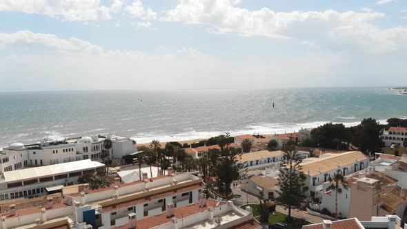 Fly over seaside houses by the sea beach, Albuferia , Portugal