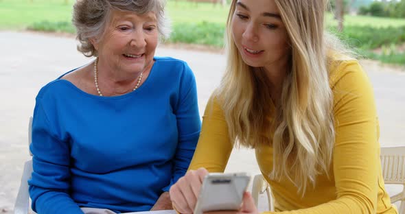 Senior Woman and Young Girl Discussing on Mobile Phone 4k