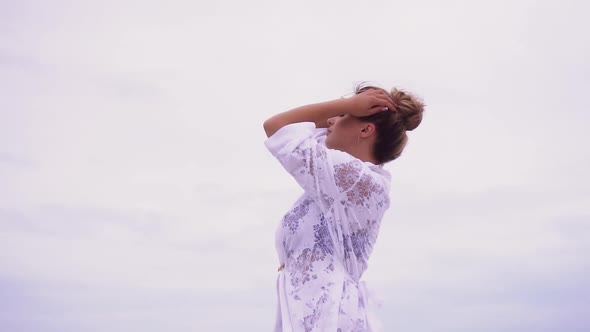 Girl Walks on the Beach on the Background of the Sea