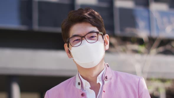 Portrait of asian man wearing face mask while standing at corporate park