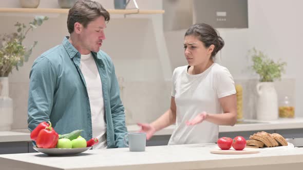 Young Indian Woman Arguing with Young Man in Kitchen