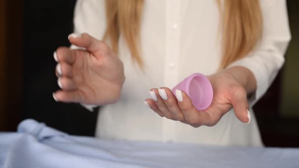 Close Up Menstrual Cup Latex Silicone in Girl Hands Holding Compress Folding