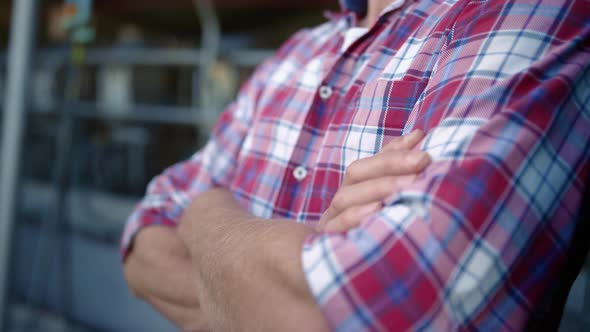 Closeup Farmer Crossed Arms at Livestock Facility