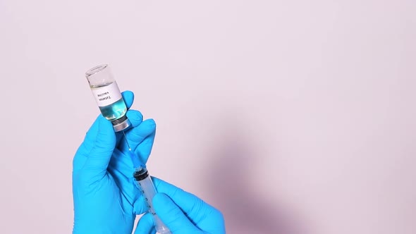 A Doctor or Lab Technician in a Medical Mask Keeps the Tetanus Vaccine on a White Background