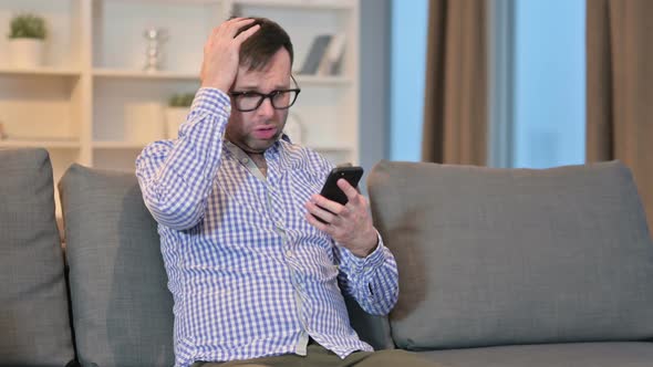 Loss, Young Man Having Failure on Smartphone at Home 