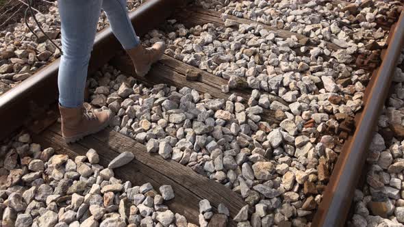 Woman steps on railroad ties and stone  4K 2160p 30fps UltraHD footage - Female walks on old train r