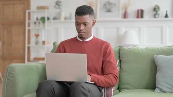 African Man Closing Laptop, Leaving Sofa