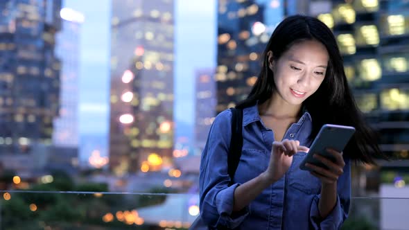 Woman use of mobile phone in the city at night 