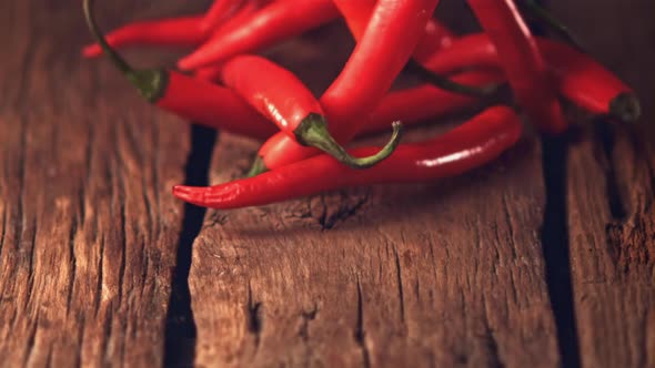 Super Slow Motion Red Chilli Rolls on Wooden Boards