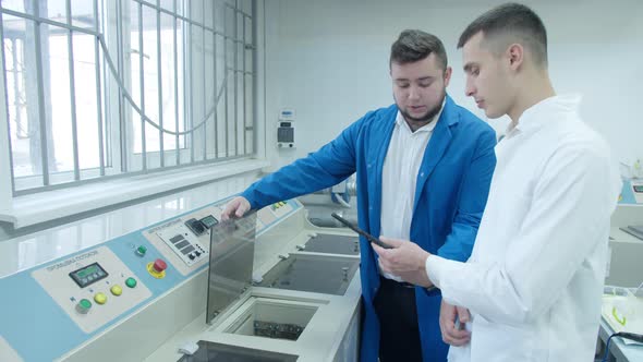 Industrial Designer and Technician Examining Equipment in Factory
