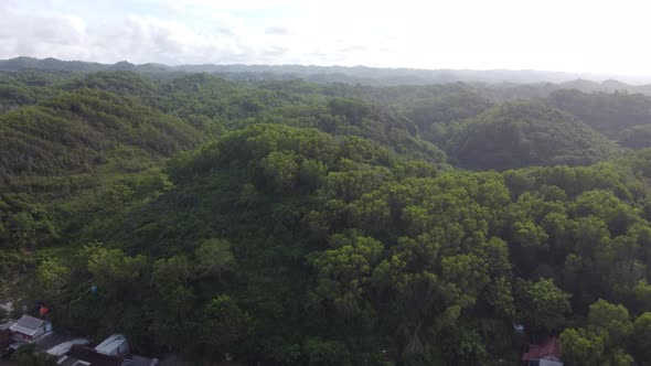 Drone flying over green mountains in the morning