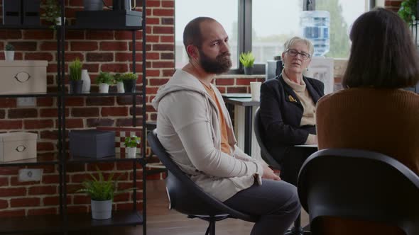 Frustrated Man Sharing Story with Group of People and Therapist at Aa Therapy Meeting