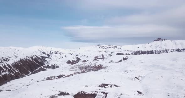 Flight over high Alborz mountain village in winter snow beautiful white landscape. Aerial scenic vie