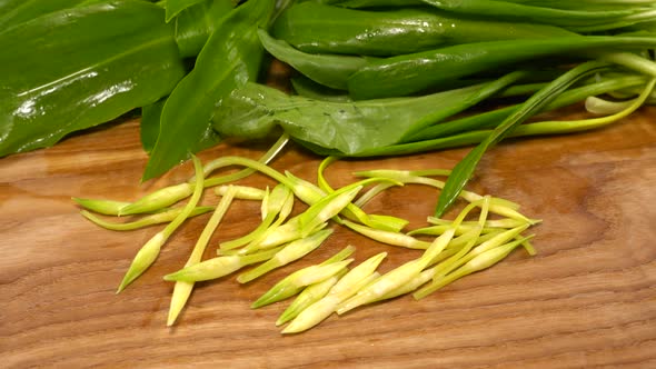 Wild garlic leaves on a wooden cutting board.