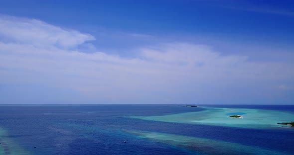 Tropical fly over tourism shot of a sunshine white sandy paradise beach and aqua blue water backgrou