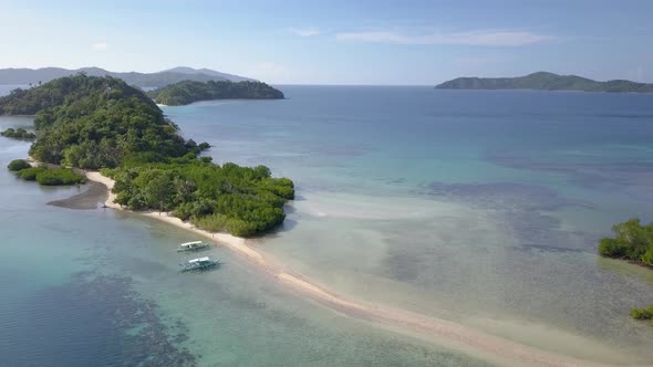 Aerial view of island with mangrove and long sandbar in the Philippines - camera pedestal down