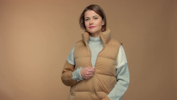 Caucasian Brunette Model in Studio on Beige Background Wear a Sleeveless Jacket