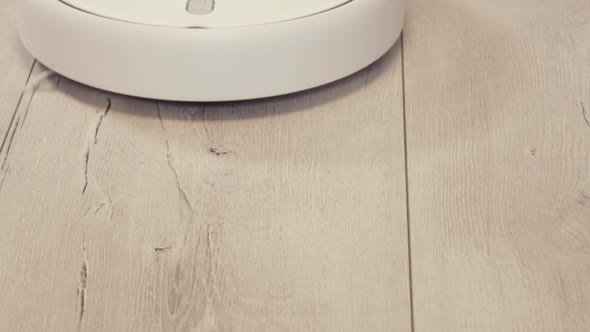 Robot vacuum cleaner vacuuming the floor in the room. Smart home with automated devices