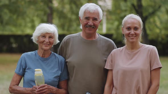 Portrait of Joyous Senior Couple and Female Fitness Coach in Park