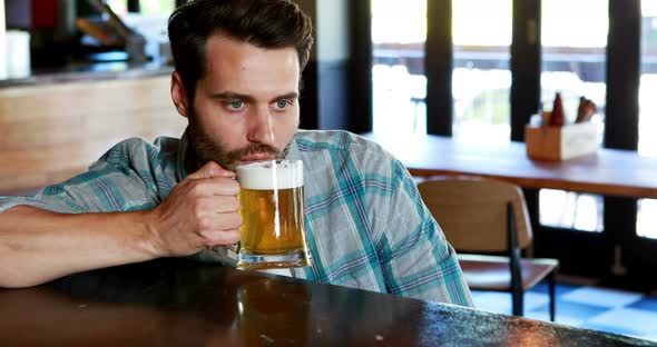 Sad man having beer at bar counter