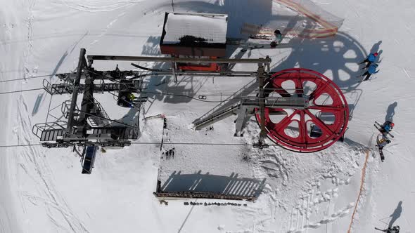Aerial Top View of Ski Lift for Transportation Skiers on Snowy Ski Slope. Drone Flies Over Chair