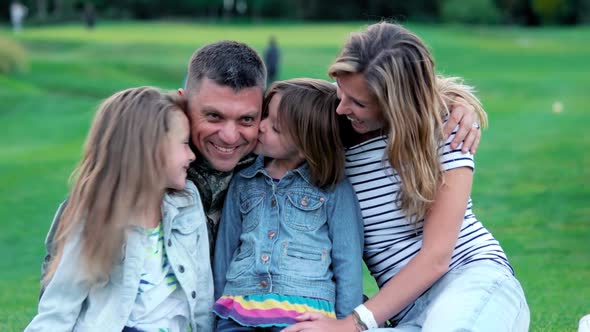 Potrait of Kids Kissing Their Soldier Father.