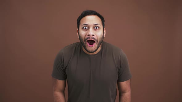 Studio Shot of Indian Man Looking at Camera with Expectation Seeing Amazing News and Enjoying Win