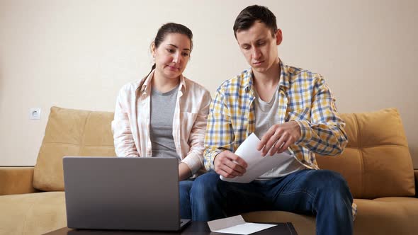 Emotional Couple Reads Apartment Purchase Agreement on Couch