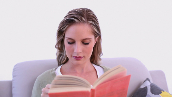 Concentrating Attractive Woman Sitting On Couch