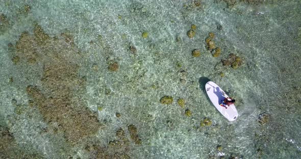 Wide drone copy space shot of a white sandy paradise beach and blue sea background in vibrant 4K