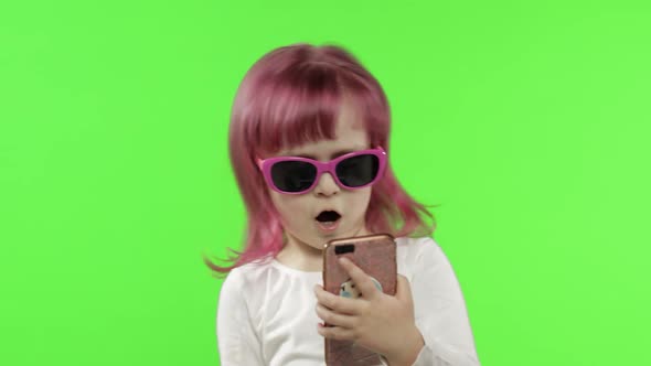 Girl Using Smartphone. Child Emotionally Talking on Mobile Phone, Take Selfie