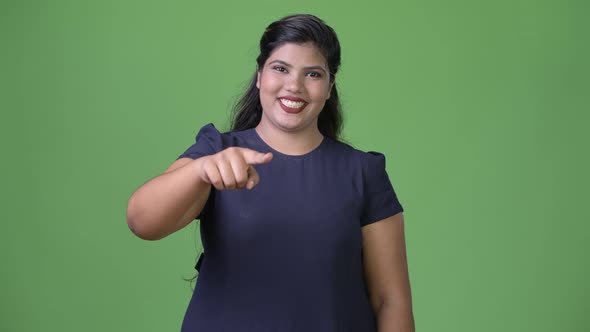 Young Overweight Beautiful Indian Businesswoman Against Green Background