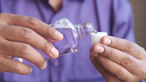 Hand Hold a Mouthwash Liquid Container