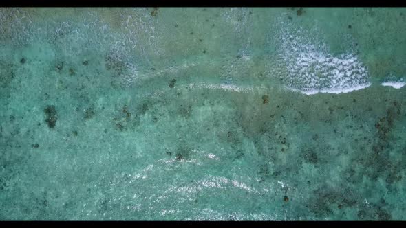 Aerial top down abstract of perfect tourist beach break by blue lagoon and white sandy background of