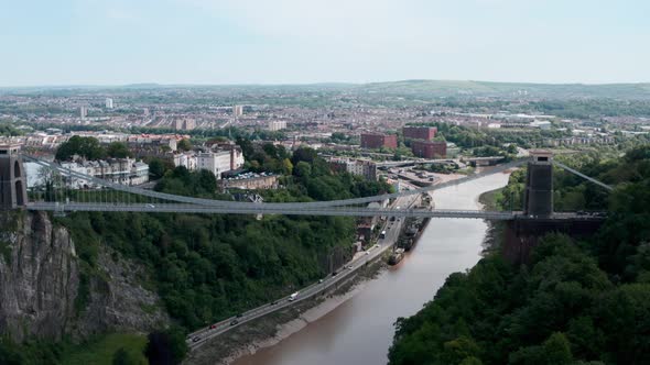 Low dolly forward drone shot over Clifton suspension bridge towards central Bristol