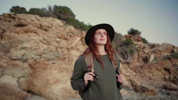 Slow motion shot of happy redheaded woman walking at coast, Ibiza