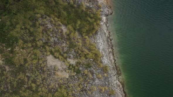 Aerial view of bird eye perspective showing the coastline with a blue greenish waterline