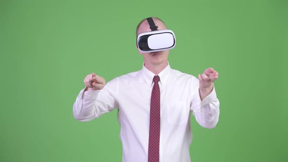 Mature Bald Businessman Using Virtual Reality Headset