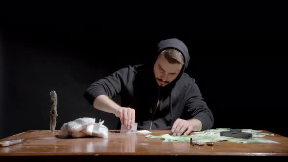 Man Forms Lines Of Cocaine Powder On The Table For Snorting. Illegal Drug And Dirty Money Concept. m