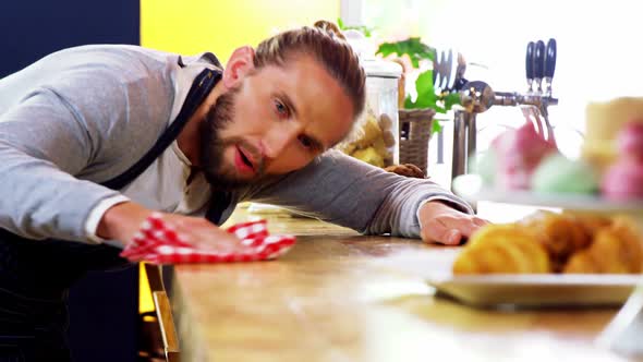 Waiter cleaning counter with napkin