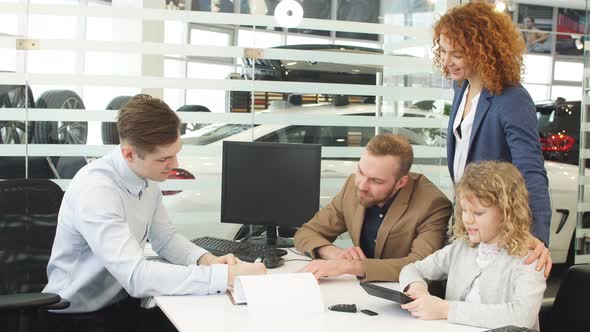 Happy Caucasian Family Sign a Document Before Buying