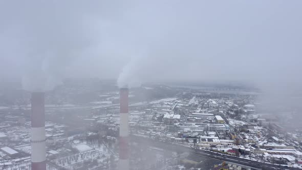 Winter View of a Big Modern Industrial City with Two Tall and Heavily Smoking Factory Pipes alt