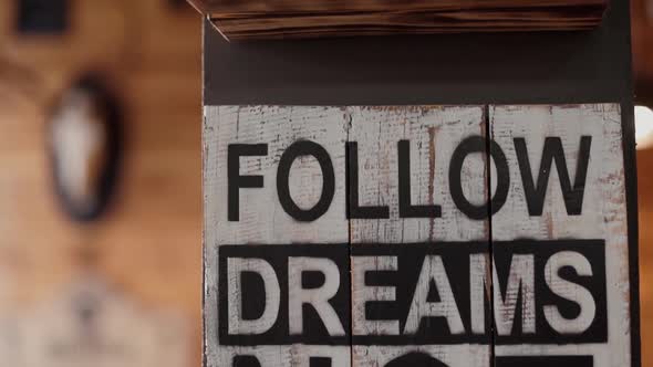 Black and White Inscription Follow Dreams on Wooden Column in the Room