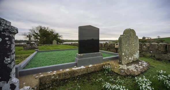 Motion time lapse of historical abbey and graveyard in rural Ireland during a cloudy day.