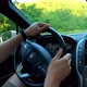 Close-up of a man's hands resting on the steering wheel of a car. Slow motion footage of the car rid - VideoHive Item for Sale