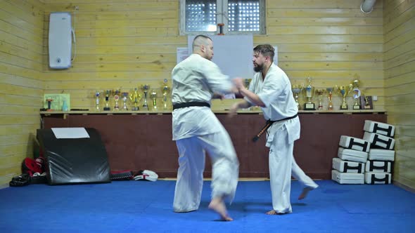 Two karate athletes train in a small provincial club
